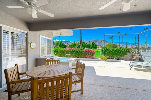 view of patio / terrace featuring ceiling fan and a mountain view