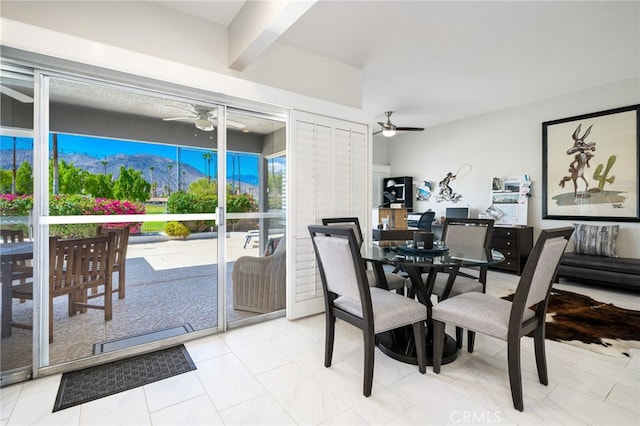 dining area with ceiling fan, a mountain view, light tile patterned flooring, and beam ceiling