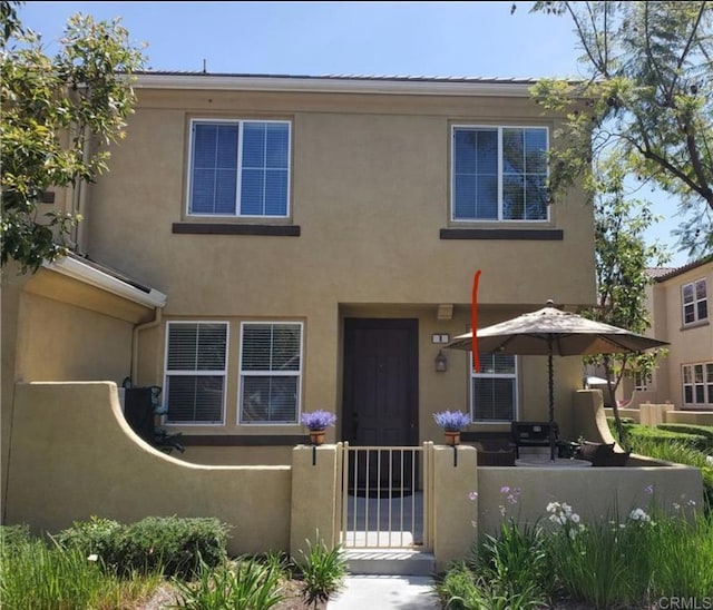 view of front of home featuring a fenced front yard, a gate, and stucco siding