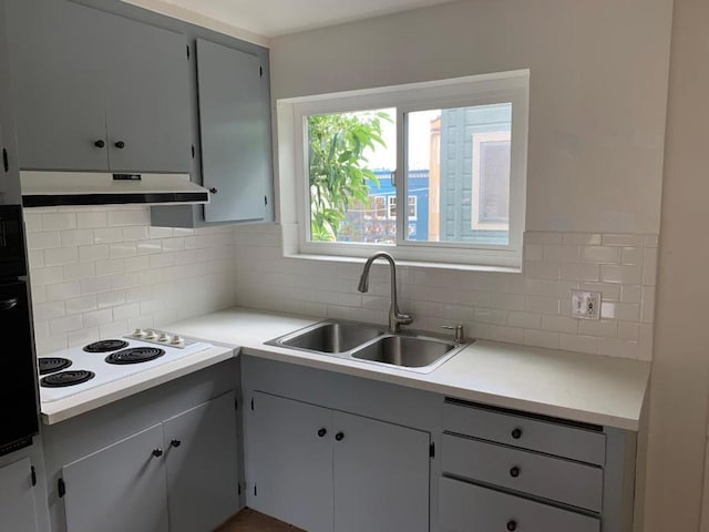 kitchen featuring gray cabinets, sink, tasteful backsplash, and white electric cooktop