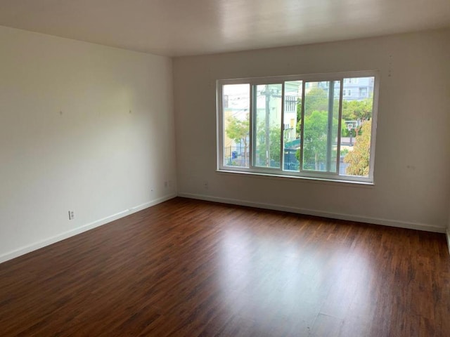 unfurnished room with dark wood-type flooring