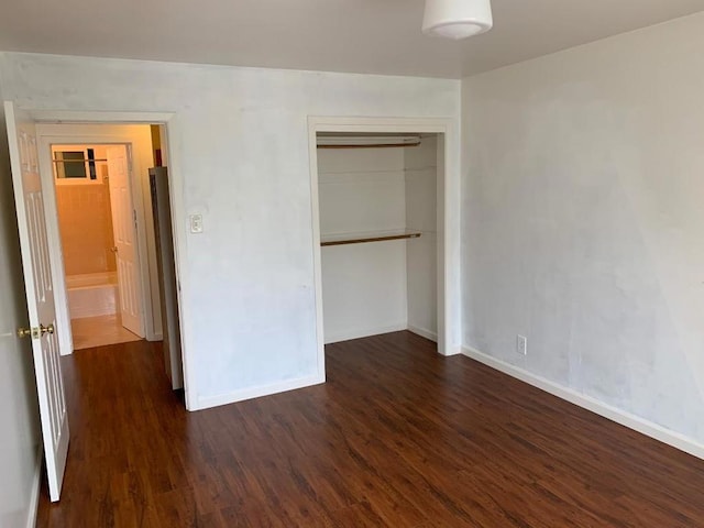 unfurnished bedroom with a closet and dark hardwood / wood-style flooring