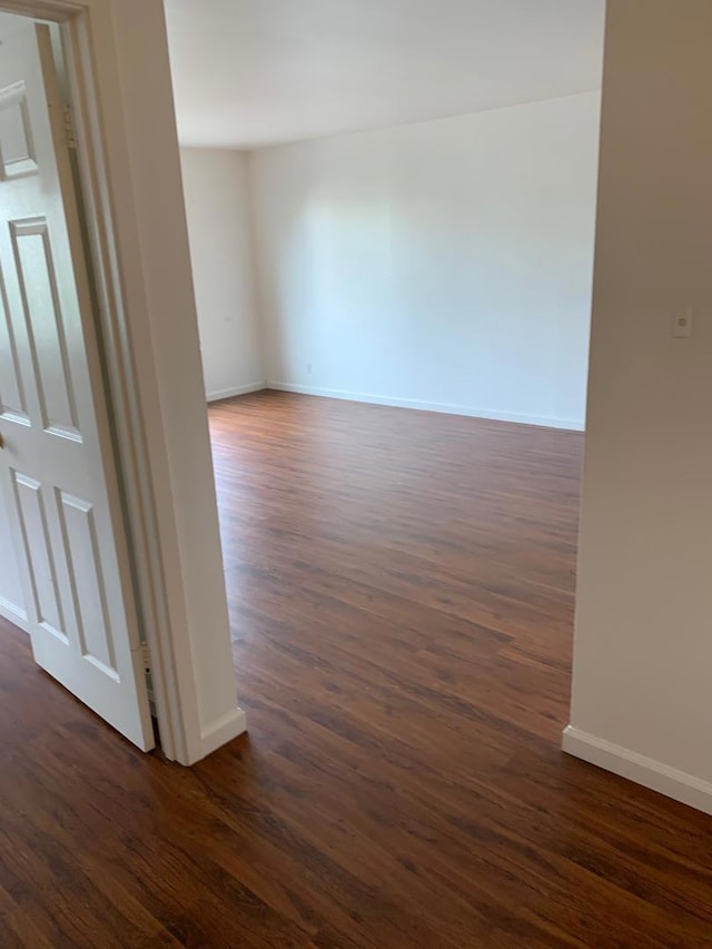 empty room with dark hardwood / wood-style flooring