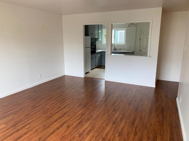 unfurnished room featuring wood-type flooring and sink