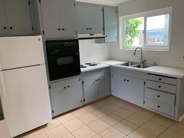 kitchen with sink, white appliances, exhaust hood, gray cabinets, and decorative backsplash