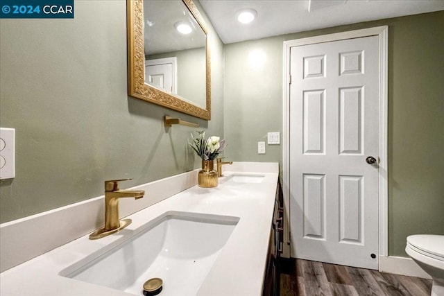 bathroom with vanity, hardwood / wood-style flooring, and toilet