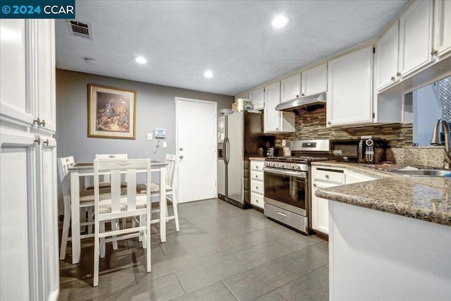 kitchen with decorative backsplash, appliances with stainless steel finishes, sink, stone countertops, and white cabinetry