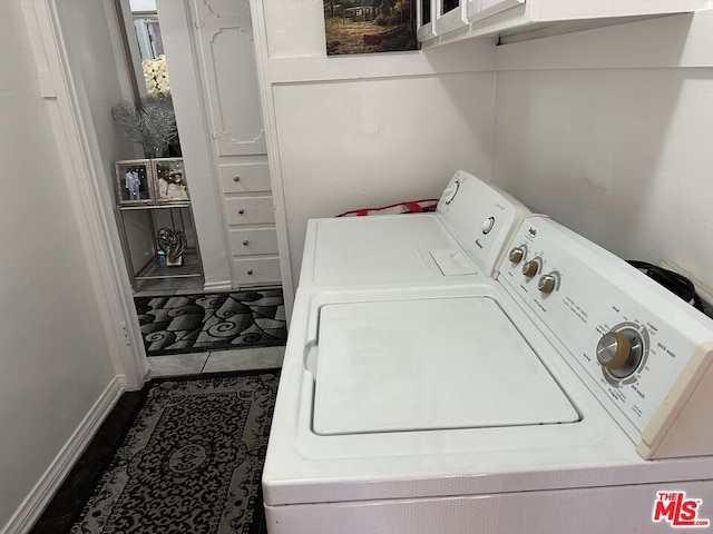 clothes washing area featuring cabinets, tile patterned floors, and washer and dryer