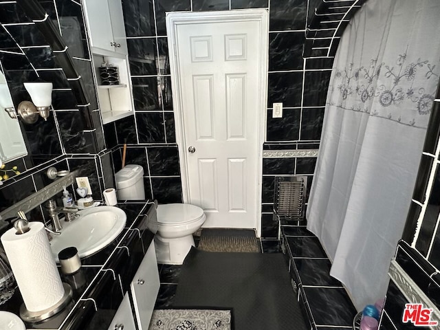 bathroom featuring tile walls, vanity, and toilet