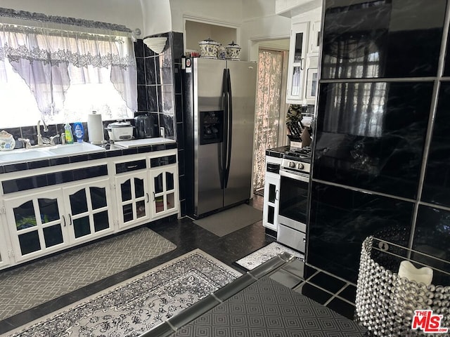 kitchen featuring white cabinets, appliances with stainless steel finishes, and tile counters