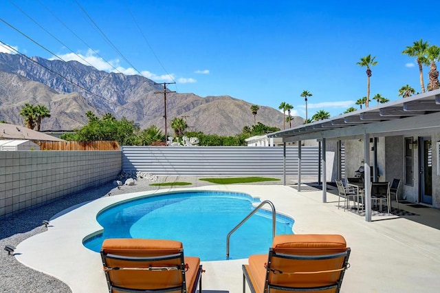 view of pool with a mountain view and a patio