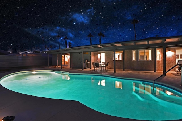 pool at twilight with a patio area