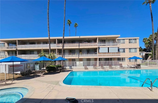 view of swimming pool featuring a community hot tub and a patio