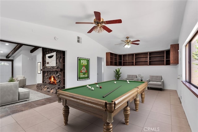 recreation room featuring pool table, vaulted ceiling, tile patterned floors, a stone fireplace, and ceiling fan