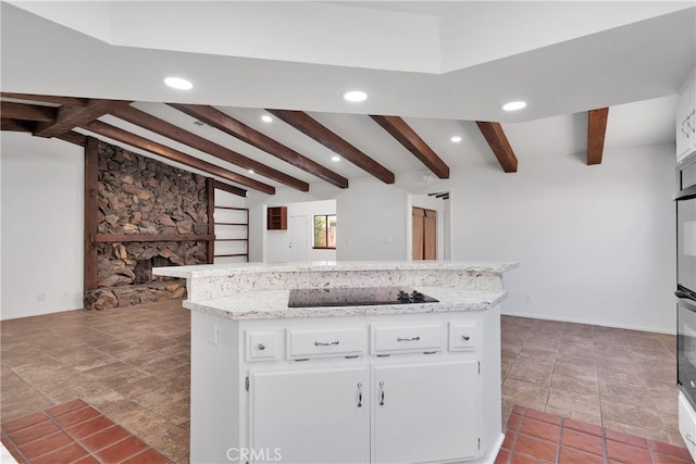 kitchen featuring black electric stovetop, a kitchen island, a fireplace, and white cabinetry