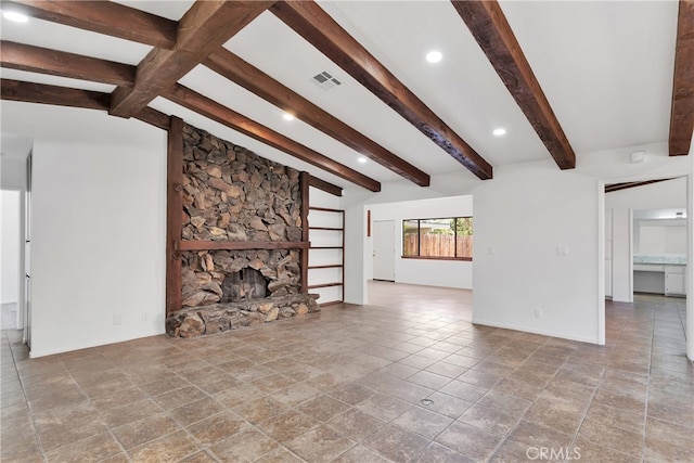 unfurnished living room with vaulted ceiling with beams and a stone fireplace