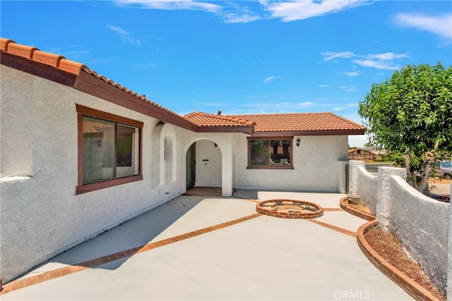 view of front of house featuring a patio and an outdoor fire pit