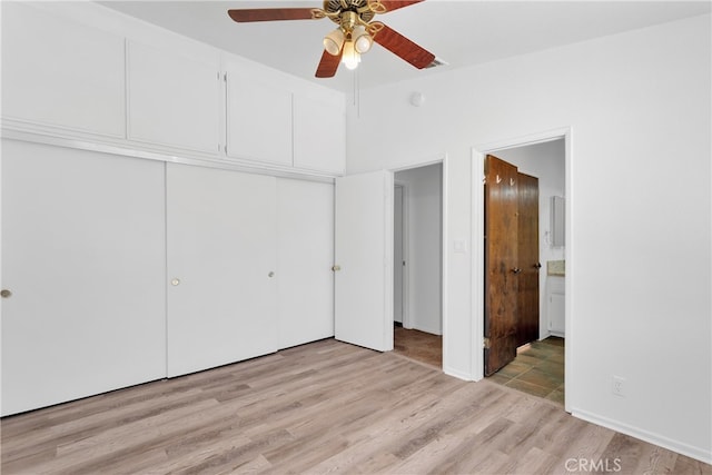 unfurnished bedroom featuring ceiling fan, light hardwood / wood-style flooring, connected bathroom, and a closet