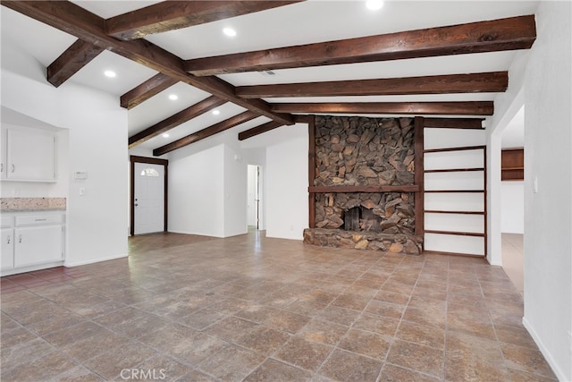 unfurnished living room with a fireplace and lofted ceiling with beams