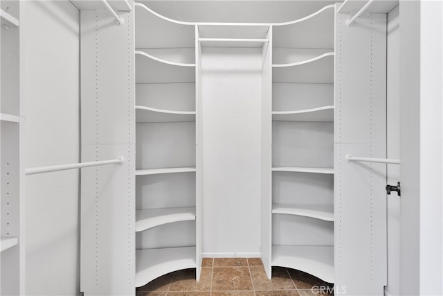 spacious closet with dark tile patterned floors