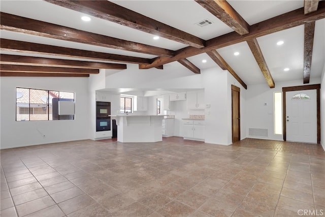 unfurnished living room with light tile patterned flooring and lofted ceiling with beams