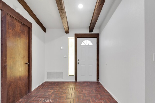 foyer entrance with beamed ceiling and dark parquet flooring