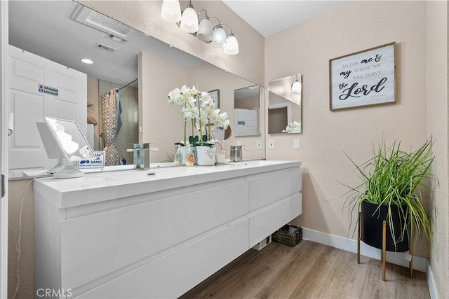 bathroom featuring wood-type flooring, vanity, and curtained shower