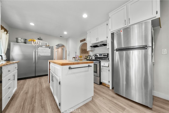 kitchen with stainless steel appliances, white cabinets, and butcher block counters