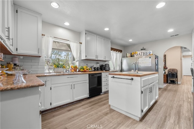 kitchen featuring white cabinets, dishwasher, a kitchen island with sink, and light hardwood / wood-style flooring