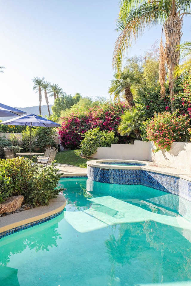 view of pool with an in ground hot tub