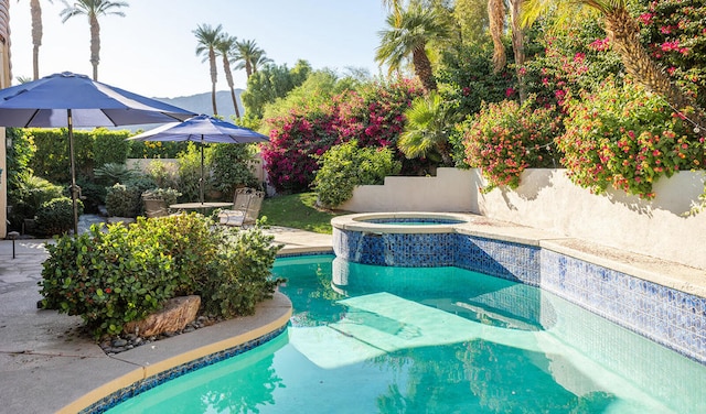 view of pool featuring a patio and an in ground hot tub