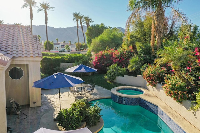 view of pool with a mountain view, an in ground hot tub, and a patio area