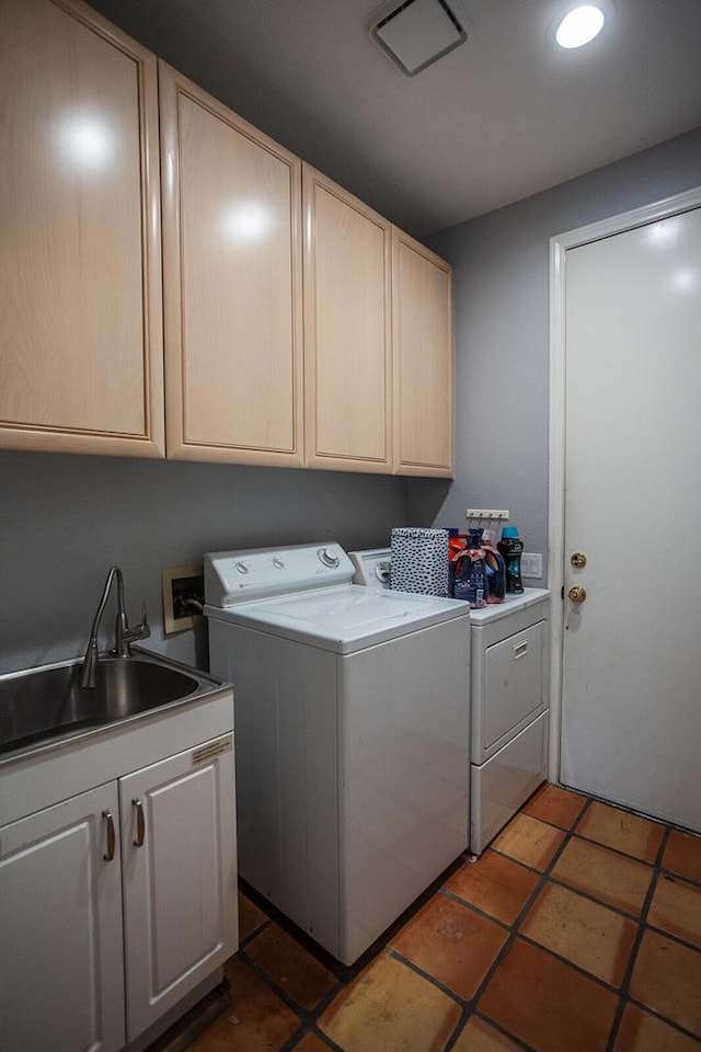 laundry area featuring cabinets, washer and clothes dryer, and sink