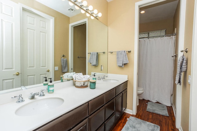 bathroom with hardwood / wood-style floors, a shower with curtain, vanity, and toilet