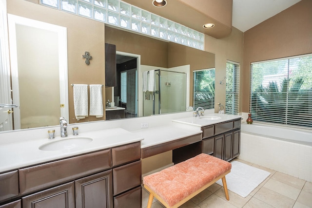 bathroom with vanity, lofted ceiling, tile patterned flooring, and separate shower and tub