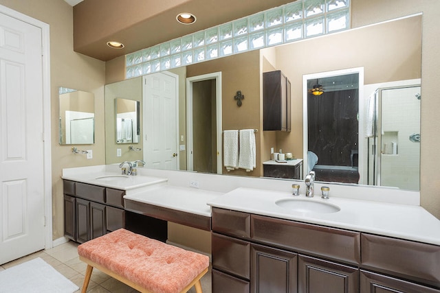 bathroom with walk in shower, vanity, and tile patterned floors