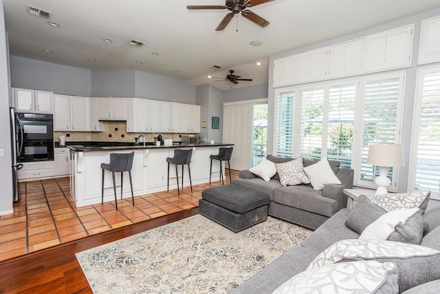 living room featuring ceiling fan, sink, and light hardwood / wood-style floors