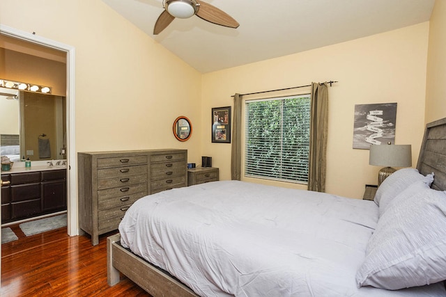 bedroom with vaulted ceiling, dark hardwood / wood-style flooring, ceiling fan, ensuite bathroom, and sink