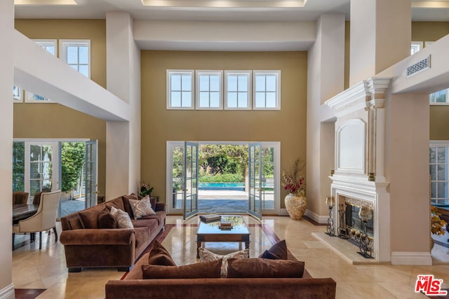 tiled living room featuring a towering ceiling and plenty of natural light