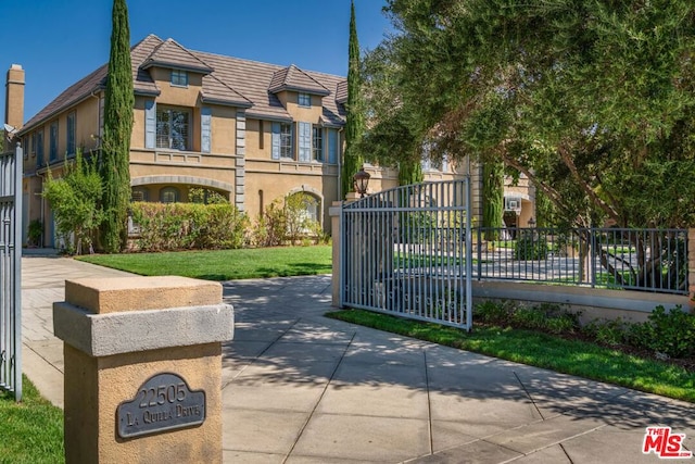 view of gate with a yard