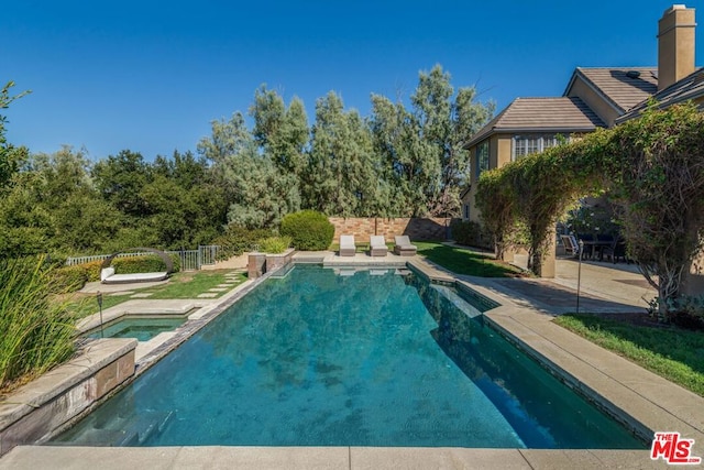 view of pool with a patio and an in ground hot tub