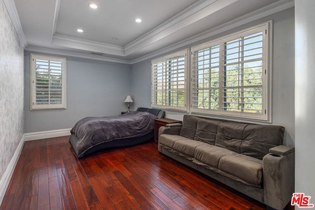 bedroom featuring ornamental molding, dark hardwood / wood-style floors, and a tray ceiling