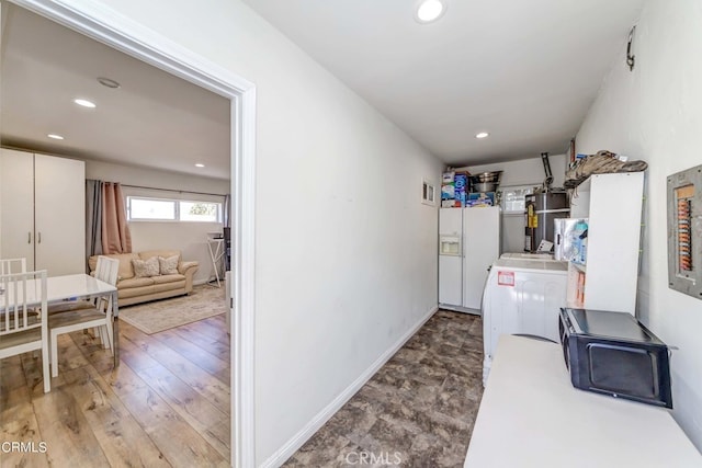 laundry area with washer / dryer, water heater, and wood-type flooring