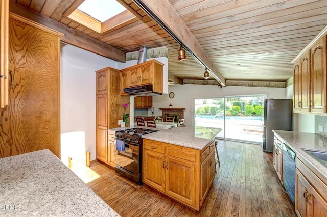 kitchen with stainless steel appliances, ventilation hood, light hardwood / wood-style floors, vaulted ceiling with skylight, and wood ceiling