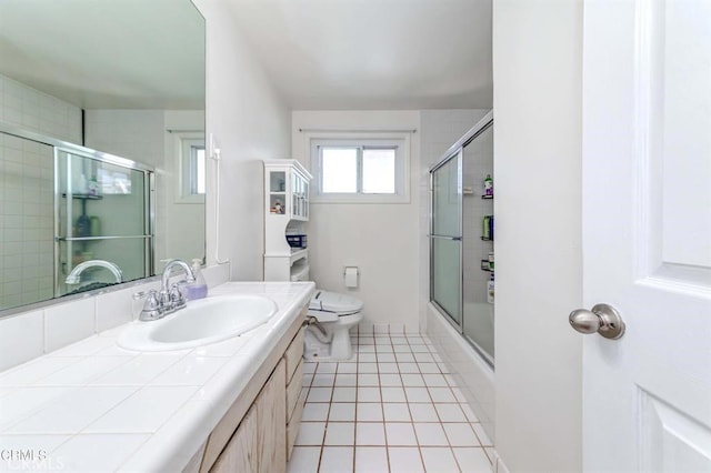 full bathroom with tile patterned flooring, vanity, toilet, and combined bath / shower with glass door