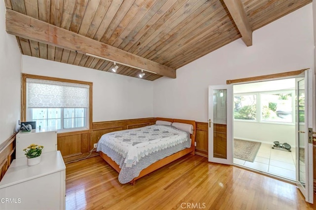 bedroom with wooden ceiling, french doors, lofted ceiling with beams, wooden walls, and light hardwood / wood-style floors