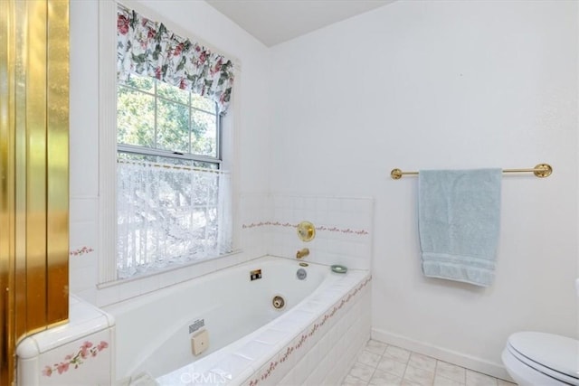 bathroom featuring toilet, tile patterned flooring, and a relaxing tiled tub