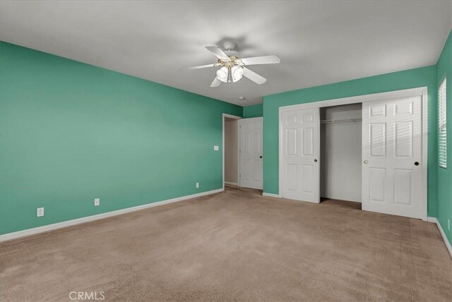 unfurnished bedroom featuring ceiling fan, a closet, and carpet flooring