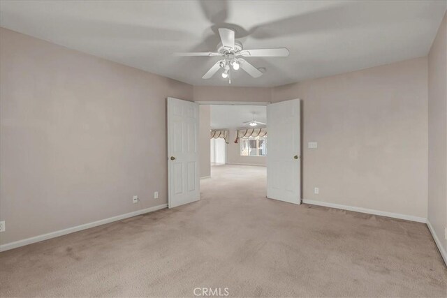 empty room featuring ceiling fan and light colored carpet