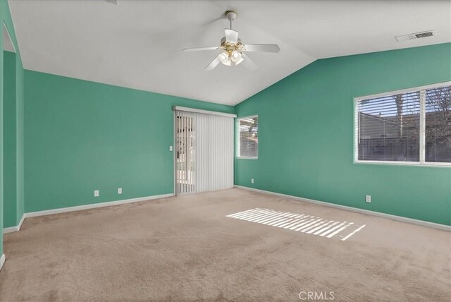 carpeted spare room featuring ceiling fan and vaulted ceiling